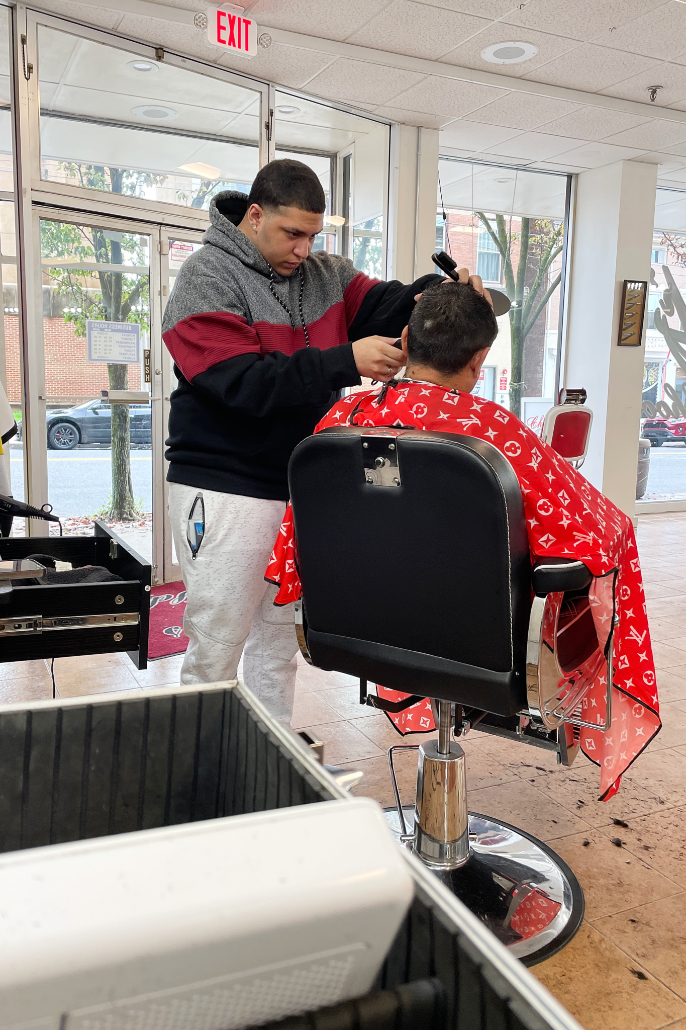 A barber giving a haircut to a customer in a modern salon.