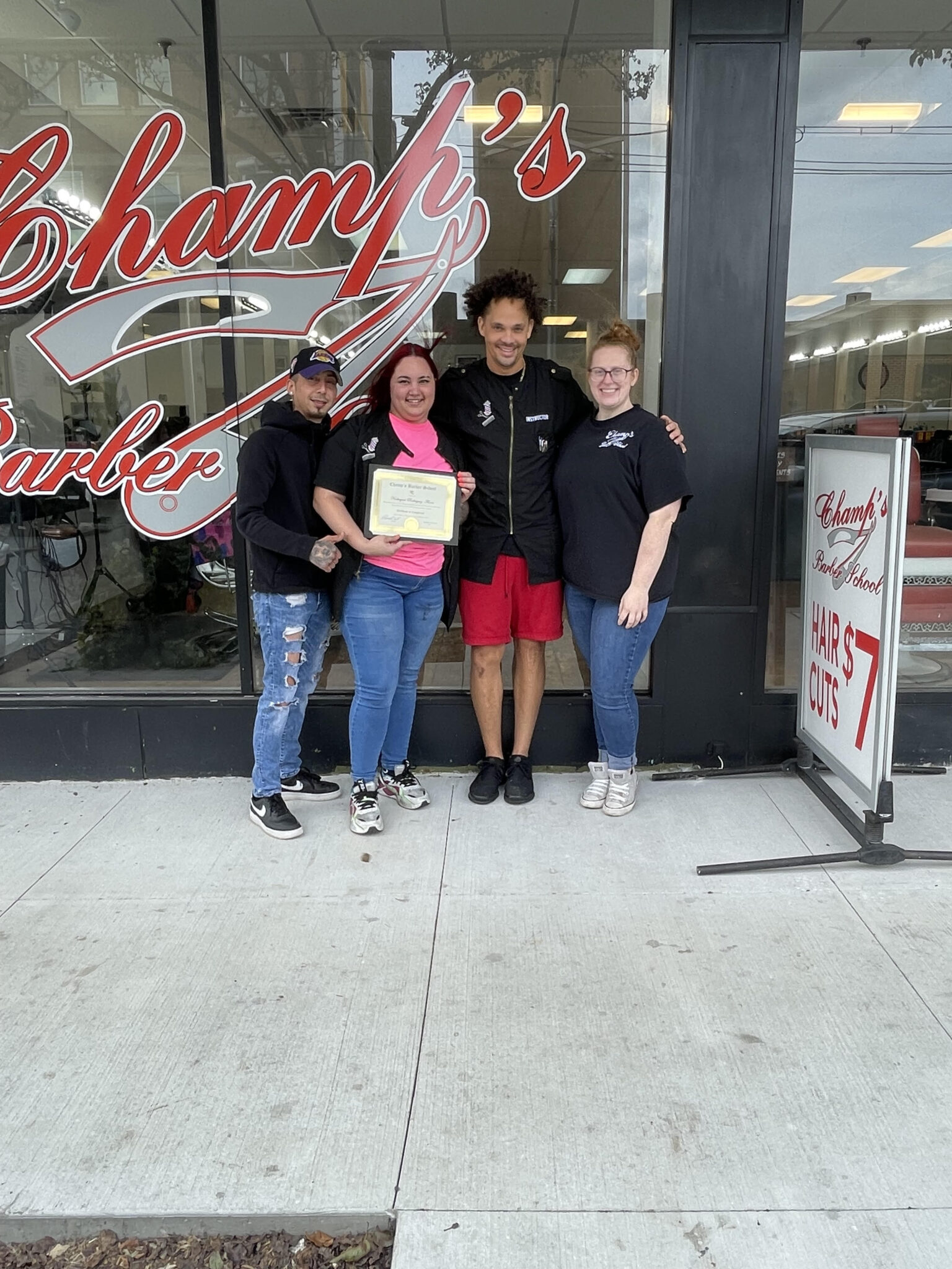 Three women happily posing outside a market with a shopping bag.